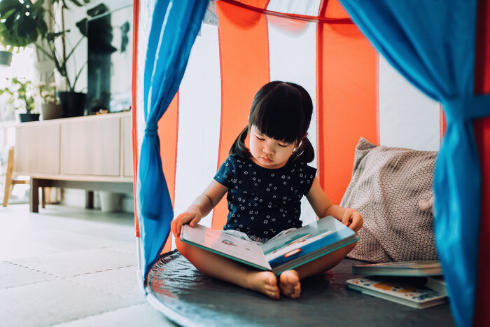 Child reading in an indoor tent